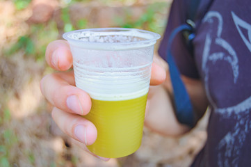 A glass of freshly squeezed reed juice in the hands of men. Rushy juice is one of popular drink in Indian cuisine. Healthy and proper food