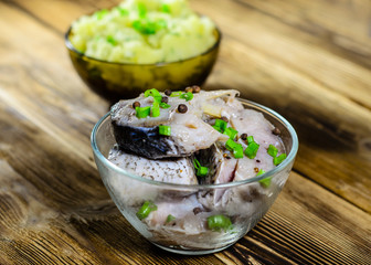 Mashed potatoes and marinated carp on wooden table