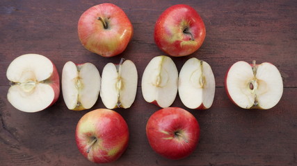 seasonal red apples sliced on wooden table, closeup