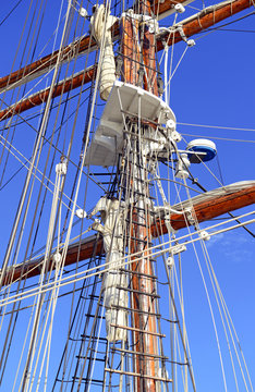 Nautical maritime scene with ropes and mast on a ship on a dock by the water