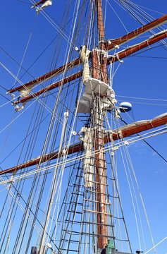 Nautical maritime scene with ropes and mast on a ship on a dock by the water