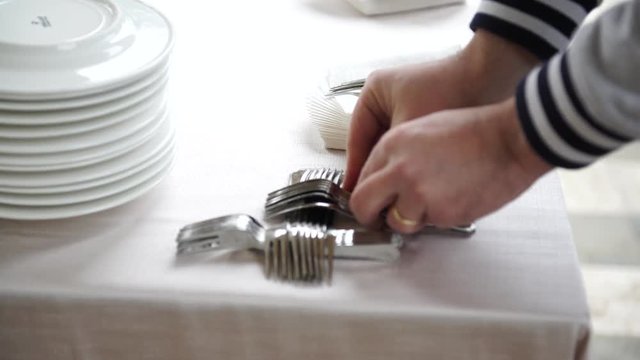 Wedding catering preparation, a waiter putting down forks for the appetisers , 4K