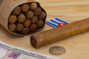 Luxury Cuban cigars and money on the wooden desk
