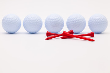White golf balls and wooden tees on the white background.
