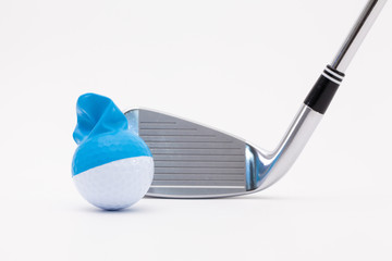 White golf ball with funny cap and golf club on the white background.