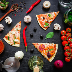 Delicious pizza with ingredients and spices on dark table. Flat lay, top view. Pizza chips
