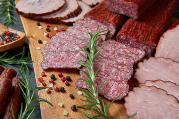 Set of cold cuts on a wooden board. Mix of sausages