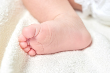 Newborn baby foot on a white towel