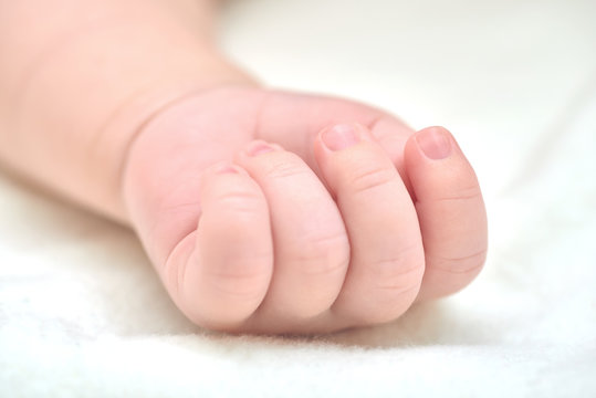 Newborn baby hand on a white towel