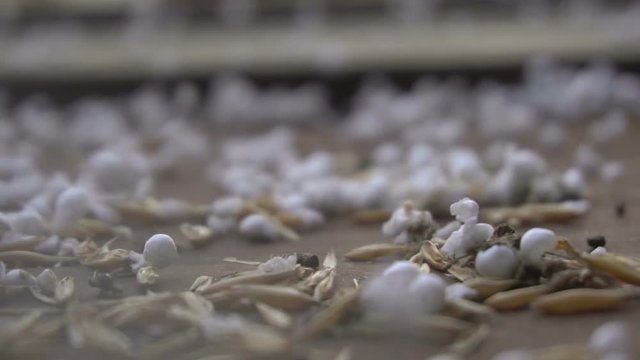 Slow motion abstract polystyrene balls with debris on the floor