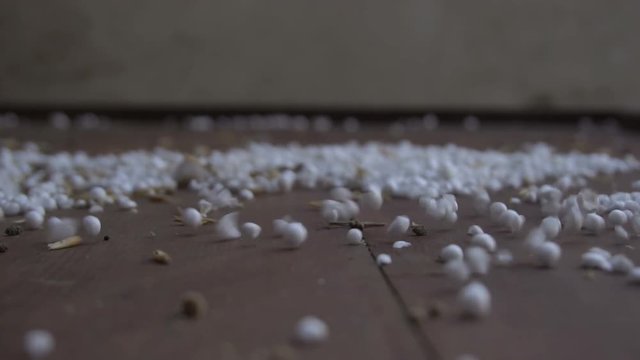 Slow motion abstract polystyrene balls with debris on the floor