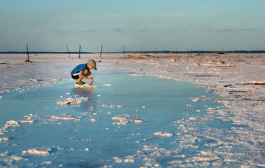 The boy collects salt crystals. Salt Plains National Wildlife Refuge, Oklahoma, US