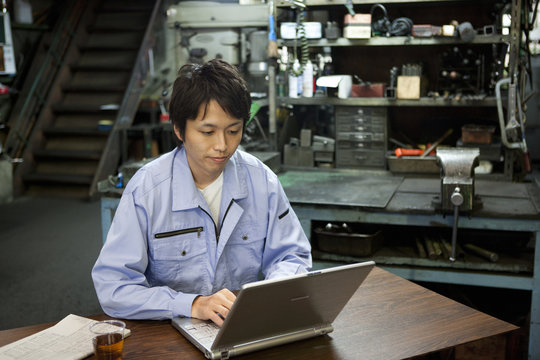 Male Factory Worker Using Laptop