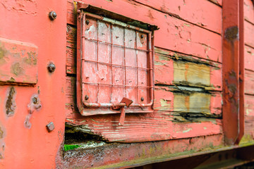 Side of an old railway wagon with flaking red paint