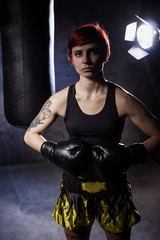 Young boxing woman in dark room