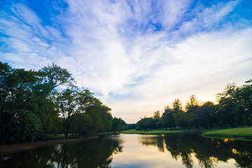 Fototapeta na wymiar Park with pond sunset colourful sky