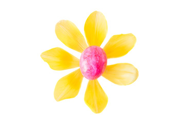 Bluehte aus einem rosa Osterei und gelben Tulpenblättern