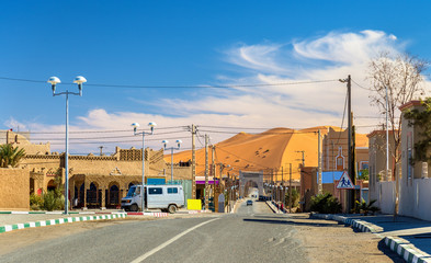 View of a Saharan dune from a street in Merzouga village, Morocco
