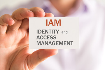 Businessman holding a card with IAM IDENTITY AND ACCESS MANAGEMENT message