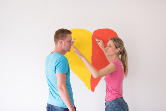 couple are painting a heart on the wall