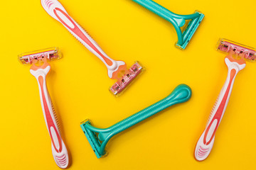 Pink and blue razors for women on a yellow background