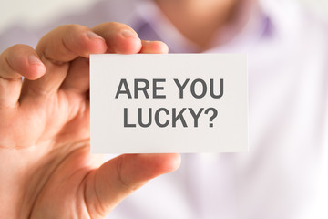Businessman holding a card with ARE YOU LUCKY ? message