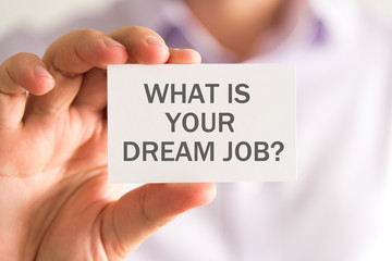 Businessman holding a card with WHAT IS YOUR DREAM JOB ? message