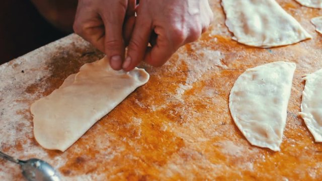 Housewife roasts chebureks in pan - Georgian national dish