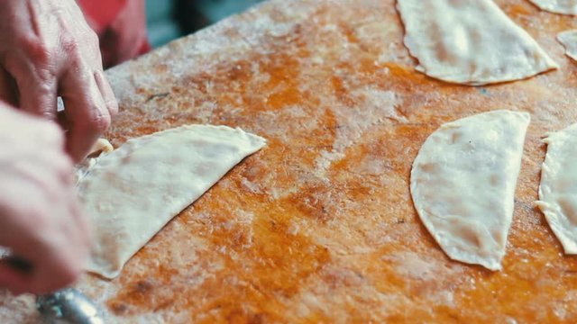 Housewife roasts chebureks in pan - Georgian national dish