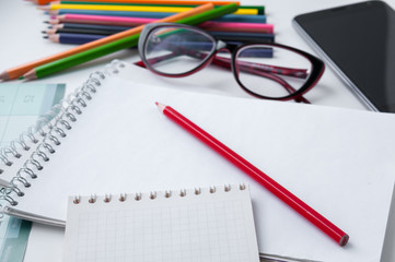 Business still-life, glasses, smart phone, notebook and colored pencils