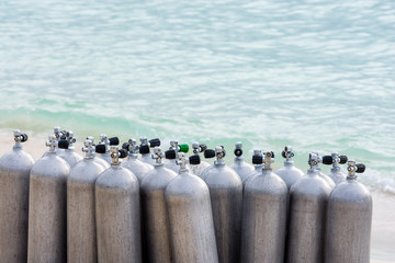 Naklejka premium A collection of scuba divers air taks on a tropical white sand beach.