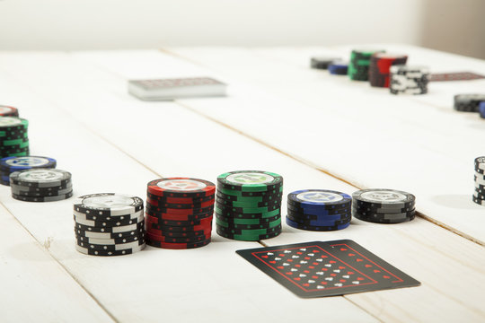 Game of poker chips and cards black on white wooden table