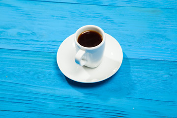 Coffee cup with espresso on blue wooden background