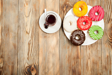 Fototapeta na wymiar Cup of tea and donuts on a wooden background