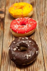 Colorful donuts on wooden background