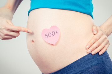Pregnant woman showing inscription 500+, social program and policy in Poland