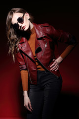 fashion model in sunglasses, beautiful young woman. leather jacket, studio shot