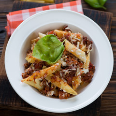 Close-up of a white glass plate with italian ziti casserole, selective focus