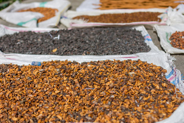 Cocoa beans other spices drying out in the street in the midday sun.
