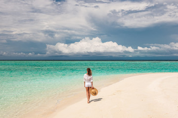 Fototapeta na wymiar Woman with sun hat on tropical beach