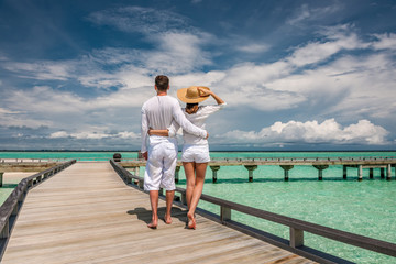 Couple in white on a beach jetty at Maldives
