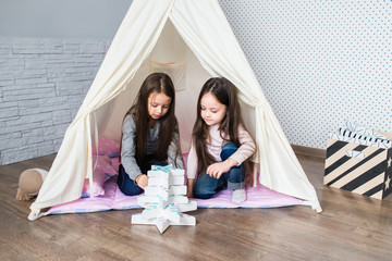 Child playing with a teepee