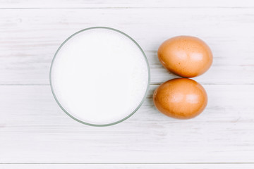 Milk and eggs on wooden background