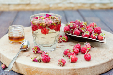 Herbal tea with rose buds and fresh raspberry.