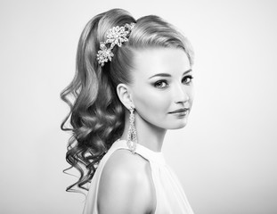 Black and white photo of beautiful woman with elegant hairstyle. Blonde girl with long wavy hair. Perfect make-up.  Beauty style woman with diamond accessories
