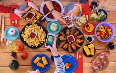 Top view of group people having dinner together while sitting at wooden table