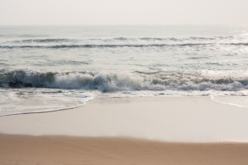 Fototapeta na wymiar Glistening waves on beach - Glistening sea waves on a tropical beach in the morning.