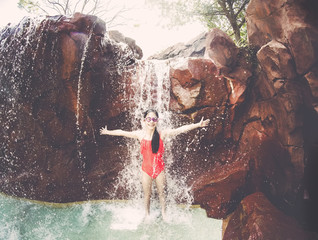 Young Girl playing and splashing in a waterfall