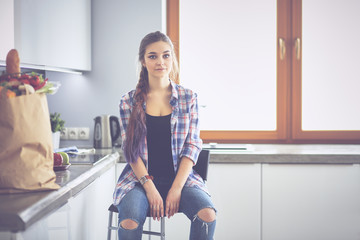 Young woman sitting near table in the kitchen