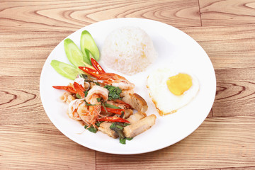 Jasmine rice topped stir - fried spicy basil with meat.